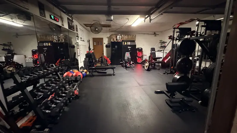 Inside the Home Bodies garage gym — dumbbell racks, mirrors and strength machines